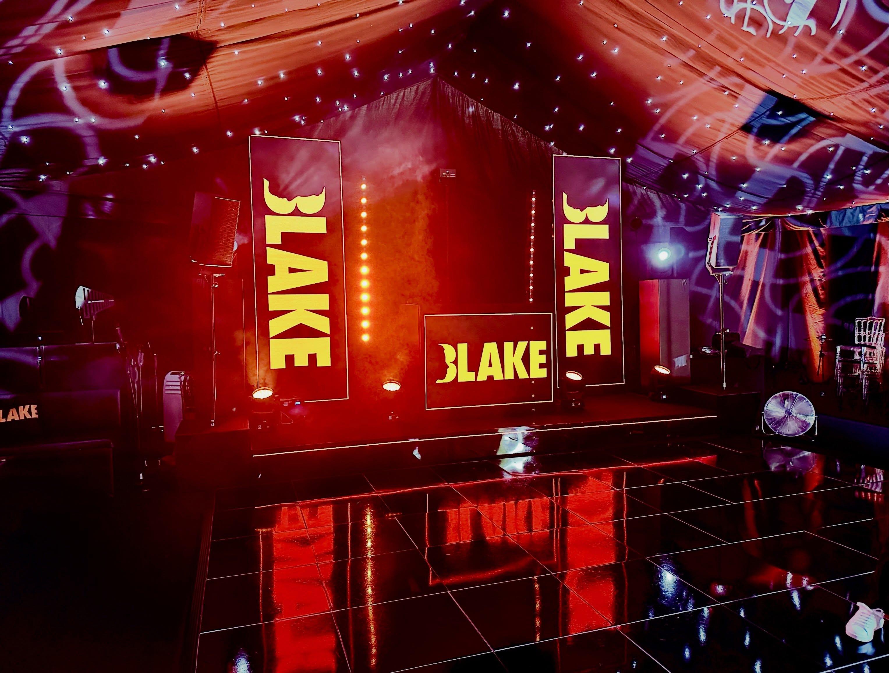 A personalised marquee transformed with video displays, lighting and a reflective dance floor