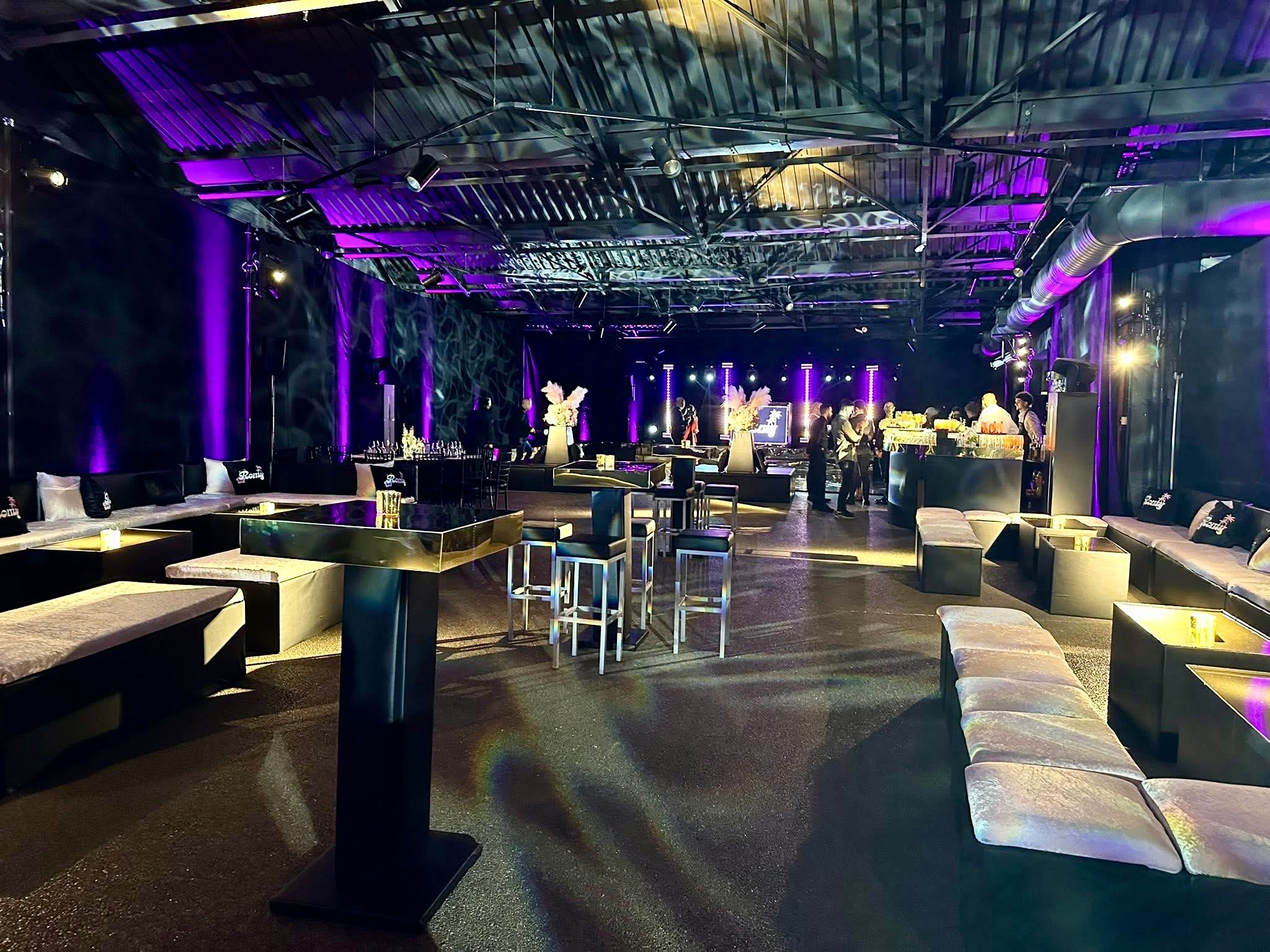 Event lounge furniture, high tables and a bar arranged for guests