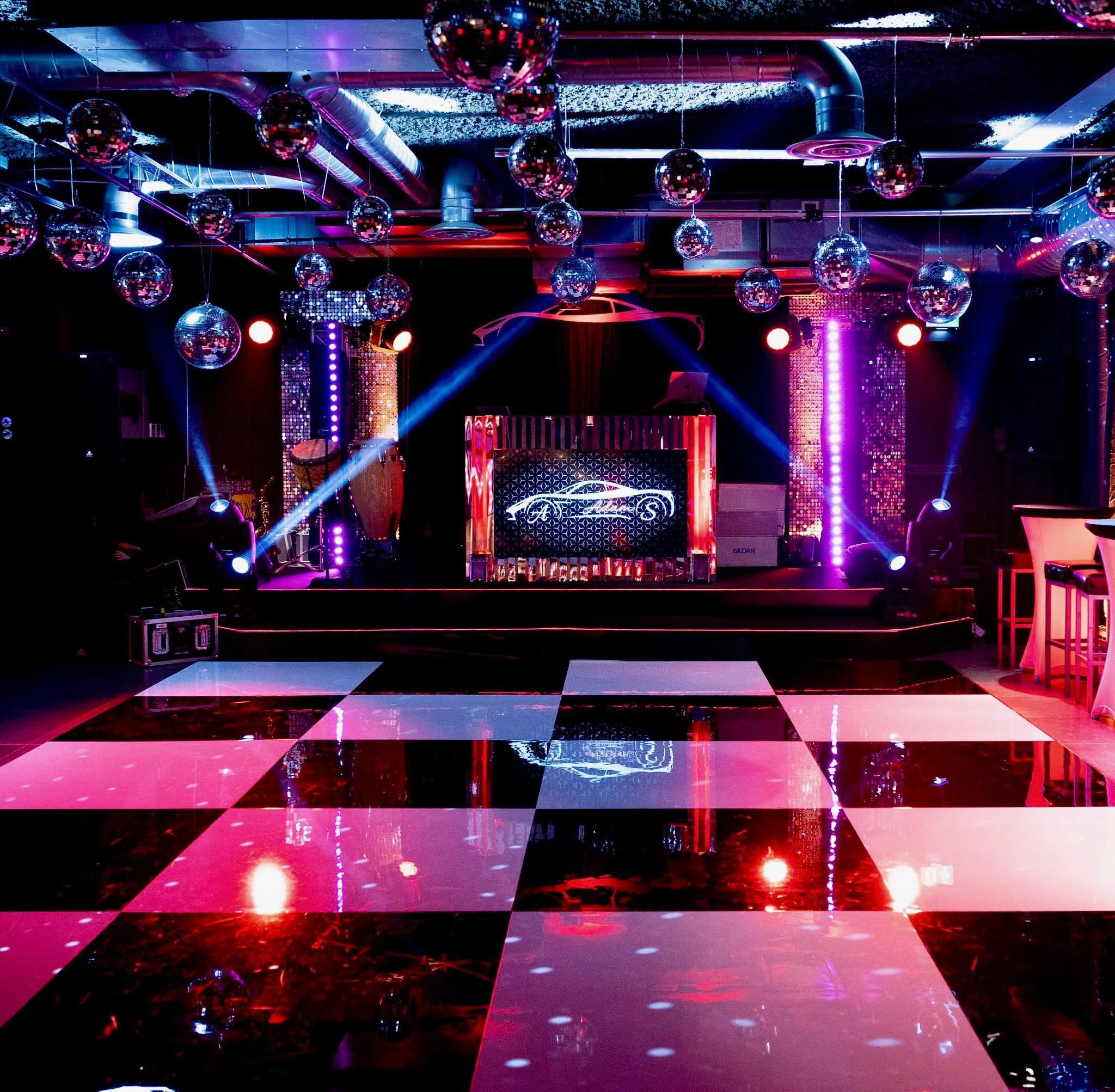 A bespoke stage, suspended mirrorballs and a striking black-and-white dance floor at a 9 Events celebration